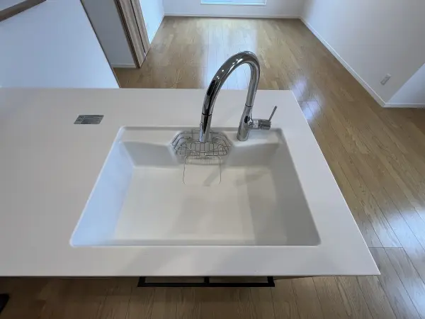 スポンジや洗剤おける場所つきの白色の流しになります