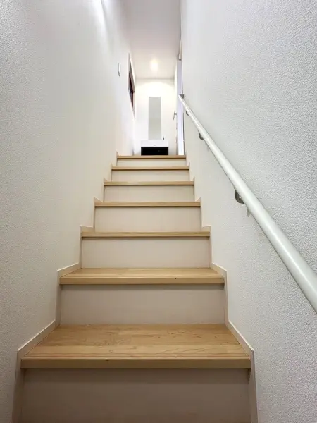 リビングから扉を介すことなく階段があり、空間に広がりを持たせつつスムーズな動線を実現しています。