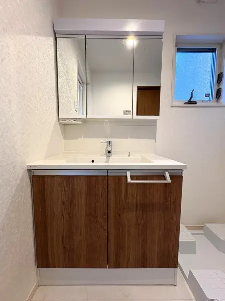 身支度のしやすい三面鏡仕様の洗面化粧台。鏡裏・洗面ボウル下部に収納スペースが設けられています。