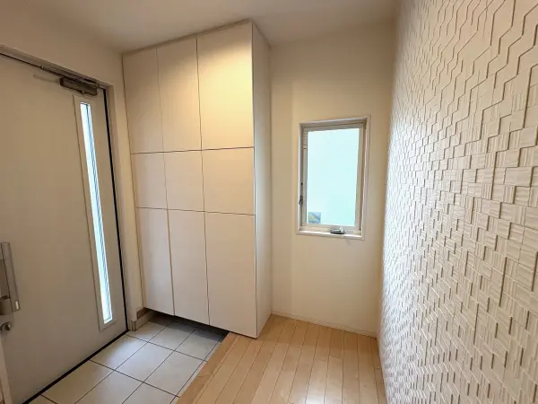 窓・ドアのスリットから陽光が差し込む明るい玄関。ダブルロックドアでセキュリティ面も配慮されています。