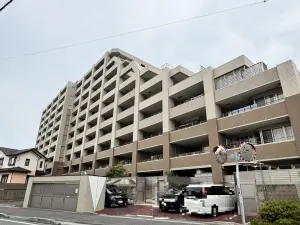 建物南東側外観写真。４階建てと１０階建ての２棟構成で、ツートンのタイル張りのフォルムとなっています